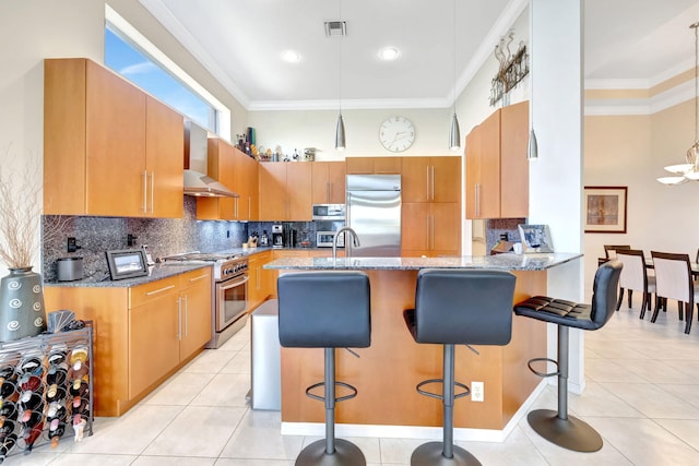 7181 Veneto Dr, Boynton Beach, FL 33437 - kitchen with premium appliances, wall chimney exhaust hood, light stone countertops, a peninsula, and backsplash