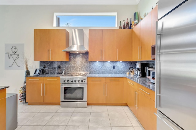 7181 Veneto Dr, Boynton Beach, FL 33437 - kitchen featuring premium appliances, wall chimney range hood, decorative backsplash, and dark stone countertops