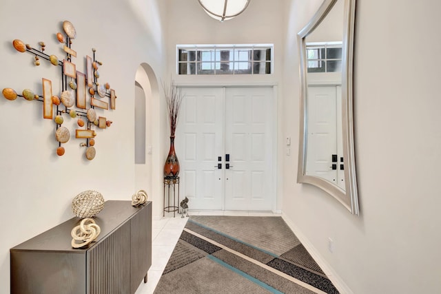 7181 Veneto Dr, Boynton Beach, FL 33437 - foyer with arched walkways, light tile patterned floors, and a high ceiling