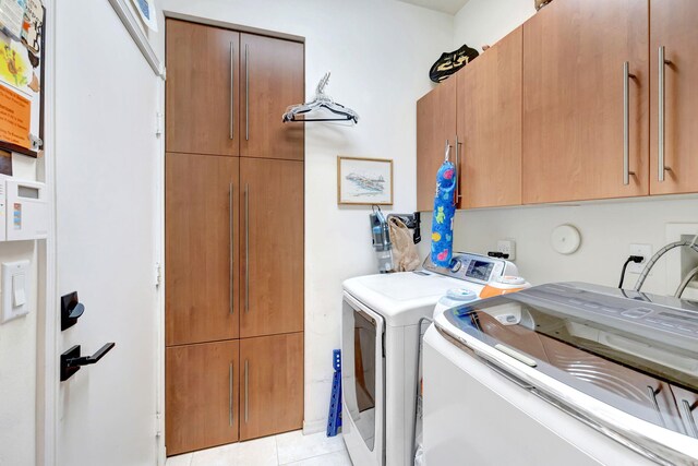 7181 Veneto Dr, Boynton Beach, FL 33437 - washroom with cabinet space, washing machine and dryer, and light tile patterned floors