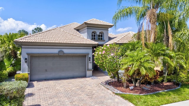 7181 Veneto Dr, Boynton Beach, FL 33437 - mediterranean / spanish house with decorative driveway, stucco siding, a tiled roof, and an attached garage