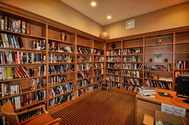 7181 Veneto Dr, Boynton Beach, FL 33437 - sitting room with wall of books, carpet flooring, and recessed lighting
