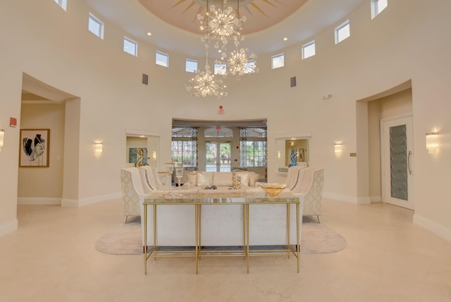 7181 Veneto Dr, Boynton Beach, FL 33437 - living area featuring a towering ceiling, a chandelier, and baseboards