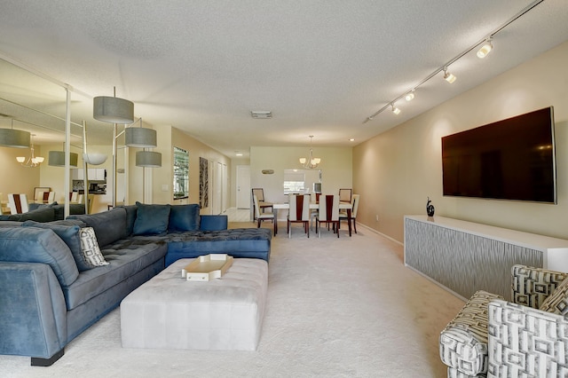 18 Westgate Ln Unit 18F, Boynton Beach, FL 33436 - living room with a chandelier, light carpet, a textured ceiling, and baseboards
