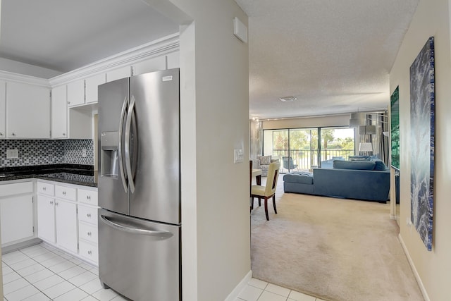 18 Westgate Ln Unit 18F, Boynton Beach, FL 33436 - kitchen featuring stainless steel refrigerator with ice dispenser, open floor plan, light tile patterned floors, dark countertops, and white cabinets