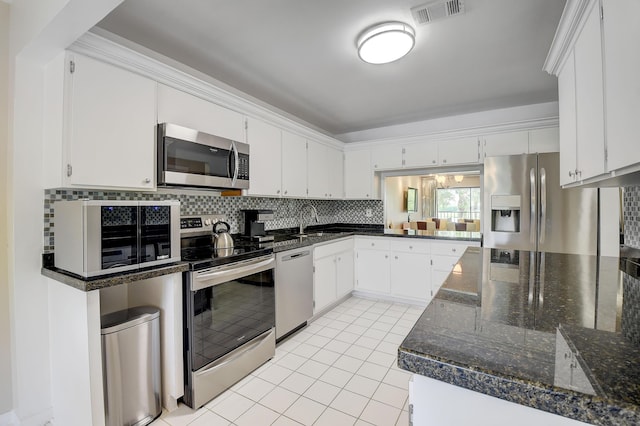 18 Westgate Ln Unit 18F, Boynton Beach, FL 33436 - kitchen featuring appliances with stainless steel finishes, tasteful backsplash, a sink, light tile patterned floors, and white cabinets