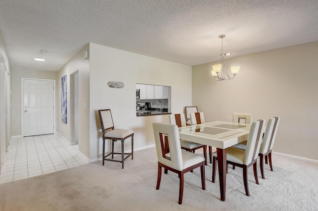 18 Westgate Ln Unit 18F, Boynton Beach, FL 33436 - dining space featuring a chandelier, light carpet, a textured ceiling, and baseboards