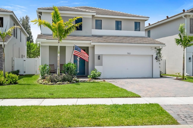 7102 Rockwood Rd, Jupiter, FL 33458 - view of front facade featuring an attached garage, decorative driveway, stucco siding, and a tile roof