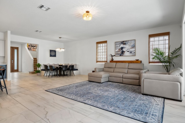 7102 Rockwood Rd, Jupiter, FL 33458 - living area featuring a chandelier, healthy amount of natural light, and marble look tile flooring