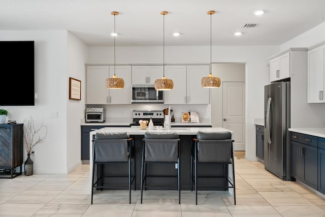 7102 Rockwood Rd, Jupiter, FL 33458 - kitchen featuring appliances with stainless steel finishes, light countertops, an island with sink, a breakfast bar, and recessed lighting
