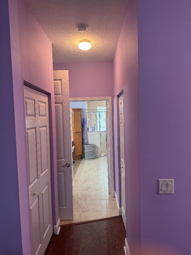 5760 NW Cleburn Dr, Port Saint Lucie, FL 34986 - hall featuring a textured ceiling and baseboards