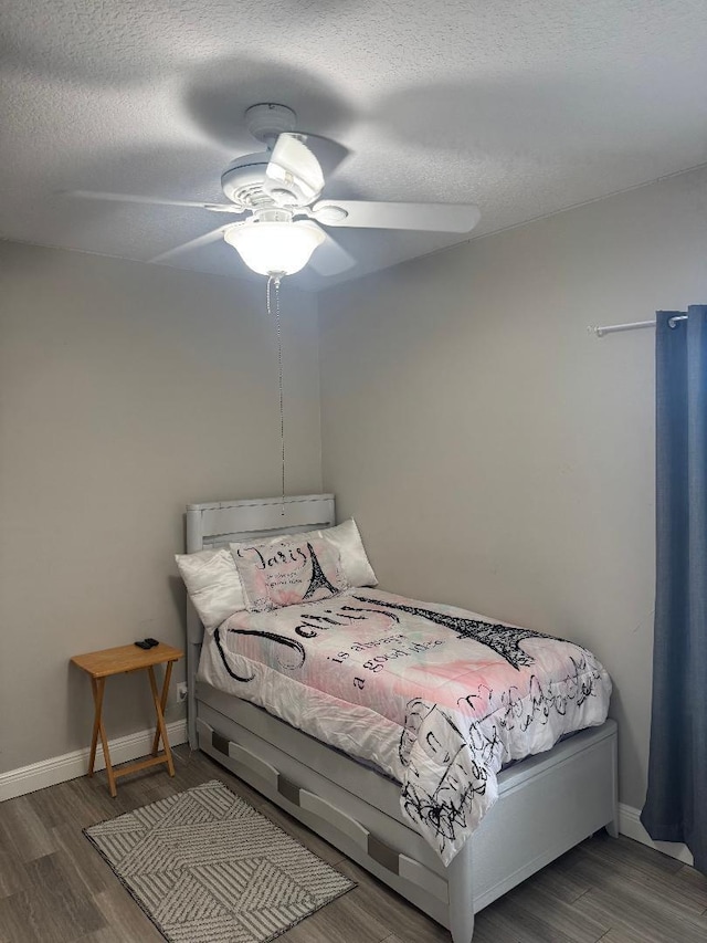 5760 NW Cleburn Dr, Port Saint Lucie, FL 34986 - bedroom featuring wood finished floors, baseboards, a ceiling fan, and a textured ceiling