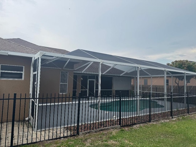 5760 NW Cleburn Dr, Port Saint Lucie, FL 34986 - back of house featuring a patio, stucco siding, and glass enclosure