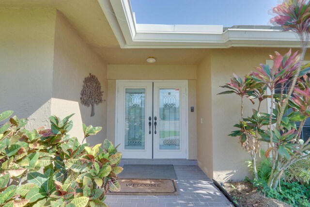 1855 Lotus Ln, Wellington, FL 33414 - view of exterior entry featuring french doors and stucco siding