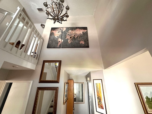 5473 E Berry Blossom Way E, West Palm Beach, FL 33415 - stairway featuring a chandelier, a textured ceiling, and a towering ceiling