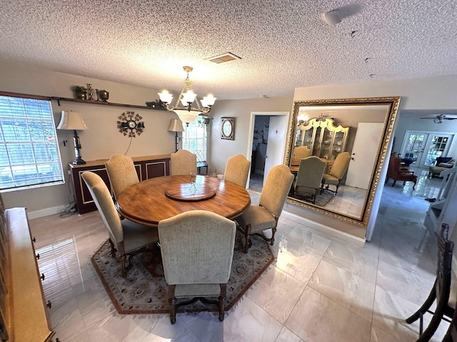 5473 E Berry Blossom Way E, West Palm Beach, FL 33415 - dining space featuring a chandelier, healthy amount of natural light, a textured ceiling, and baseboards