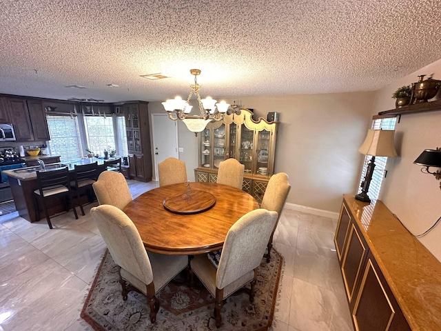 5473 E Berry Blossom Way E, West Palm Beach, FL 33415 - dining area featuring a chandelier and a textured ceiling