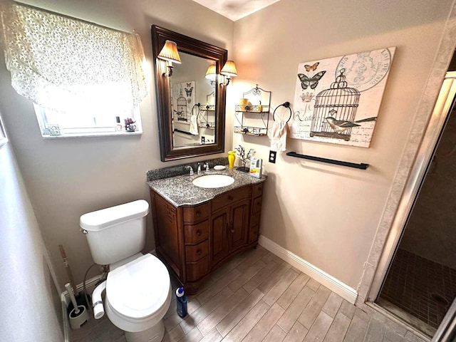5473 E Berry Blossom Way E, West Palm Beach, FL 33415 - bathroom featuring vanity, toilet, a stall shower, wood finished floors, and baseboards