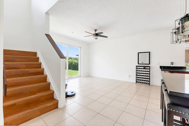 3769 Pebblebrook Ct, Coconut Creek, FL 33073 - unfurnished living room with stairs, ceiling fan, light tile patterned floors, and a textured ceiling