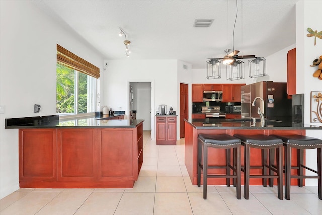 3769 Pebblebrook Ct, Coconut Creek, FL 33073 - kitchen with stainless steel appliances, a peninsula, dark countertops, and a ceiling fan