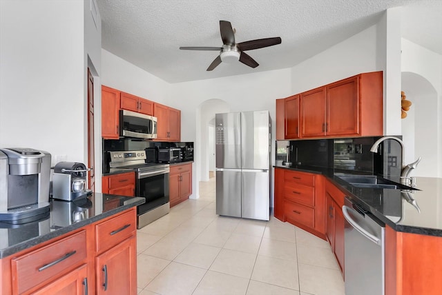 3769 Pebblebrook Ct, Coconut Creek, FL 33073 - kitchen featuring appliances with stainless steel finishes, a sink, arched walkways, ceiling fan, and a textured ceiling