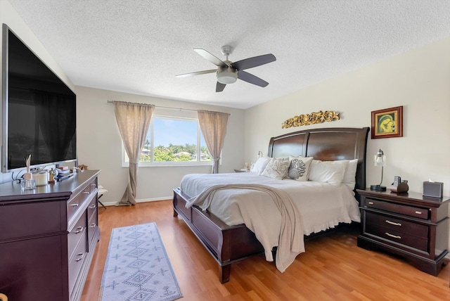 3769 Pebblebrook Ct, Coconut Creek, FL 33073 - bedroom with light wood-type flooring, a textured ceiling, ceiling fan, and baseboards