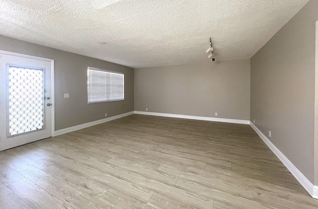 222 Piedmont E, Delray Beach, FL 33484 - empty room with light wood-style floors, a textured ceiling, plenty of natural light, and baseboards