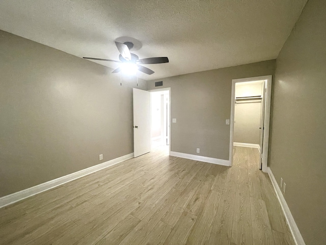 222 Piedmont E, Delray Beach, FL 33484 - spare room with light wood-style flooring, ceiling fan, a textured ceiling, and baseboards