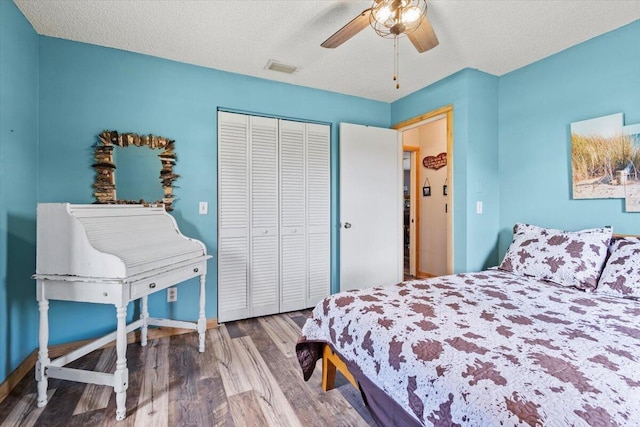 5706 Eagle Dr, Fort Pierce, FL 34950 - bedroom featuring wood finished floors, a closet, ceiling fan, baseboards, and a textured ceiling