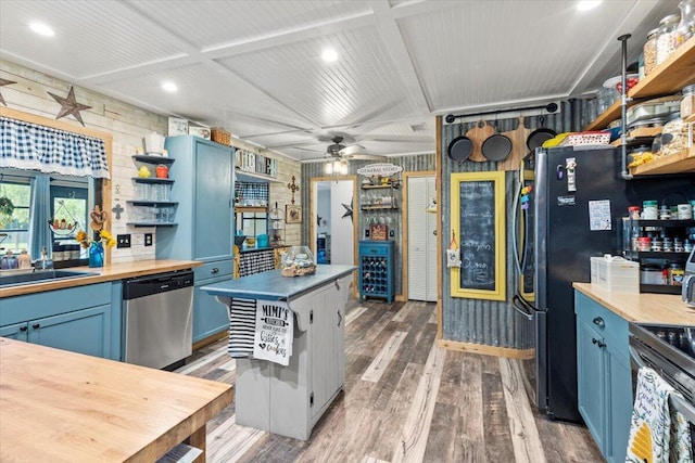 5706 Eagle Dr, Fort Pierce, FL 34950 - kitchen with stainless steel appliances, open shelves, blue cabinetry, wooden counters, and wood finished floors
