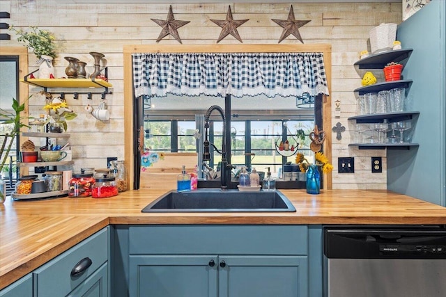 5706 Eagle Dr, Fort Pierce, FL 34950 - kitchen featuring stainless steel dishwasher, wooden counters, open shelves, a sink, and blue cabinetry