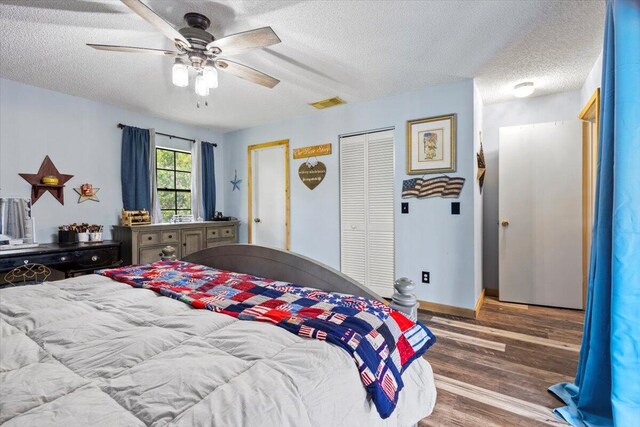 5706 Eagle Dr, Fort Pierce, FL 34950 - bedroom with a textured ceiling, wood finished floors, ceiling fan, baseboards, and a closet