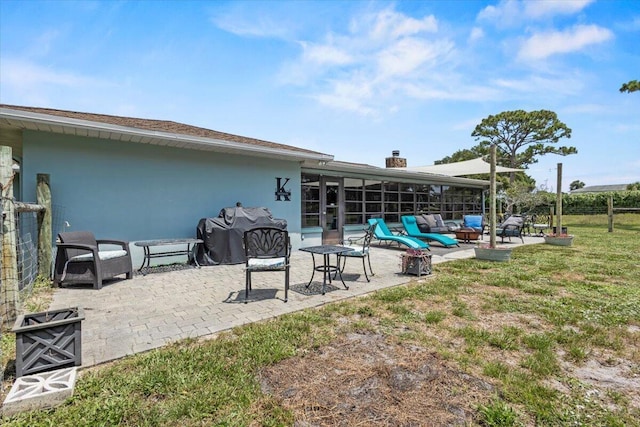 5706 Eagle Dr, Fort Pierce, FL 34950 - back of property with a patio, a sunroom, a yard, a chimney, and stucco siding