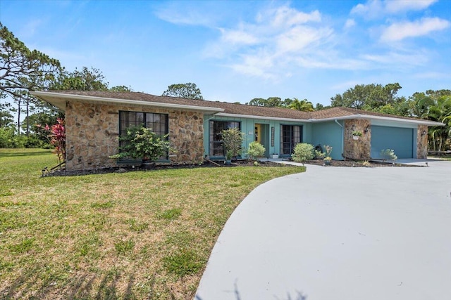 5706 Eagle Dr, Fort Pierce, FL 34950 - view of front of house with an attached garage, stone siding, a front yard, and driveway