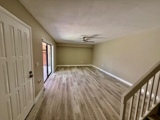 3611 SW Sunset Trace Cir, Palm City, FL 34990 - spare room with a ceiling fan, wood finished floors, baseboards, and stairway