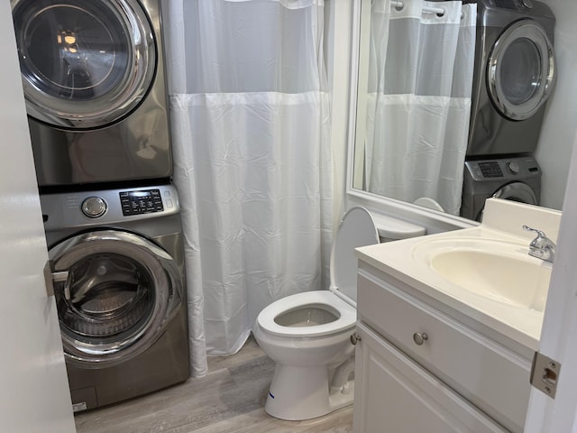 3611 SW Sunset Trace Cir, Palm City, FL 34990 - bathroom with estacked washer and dryer, wood finished floors, vanity, toilet, and a shower with shower curtain