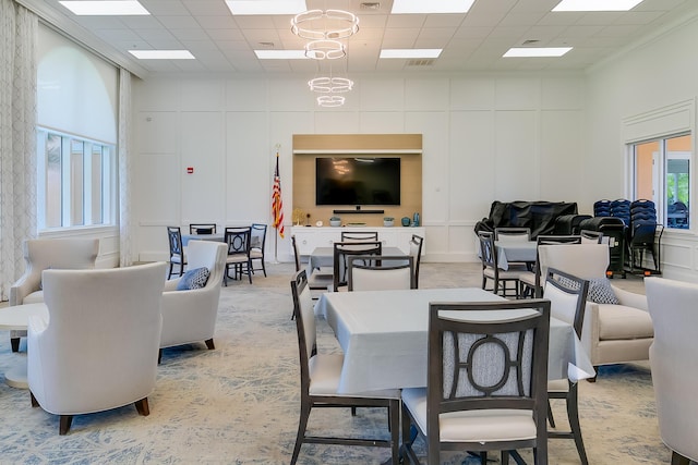 10581 SW Stratton Dr, Port Saint Lucie, FL 34987 - dining space with a decorative wall, a paneled ceiling, light carpet, and a towering ceiling