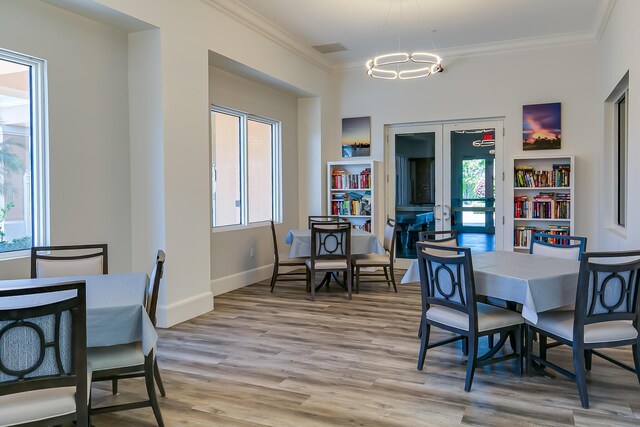 10581 SW Stratton Dr, Port Saint Lucie, FL 34987 - dining area featuring ornamental molding, a chandelier, light wood-style flooring, baseboards, and french doors