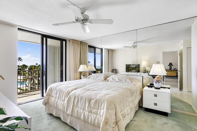 200 Ocean Trail Way Unit 106, Jupiter, FL 33477 - bedroom with access to exterior, light carpet, a textured ceiling, a wall of windows, and a ceiling fan