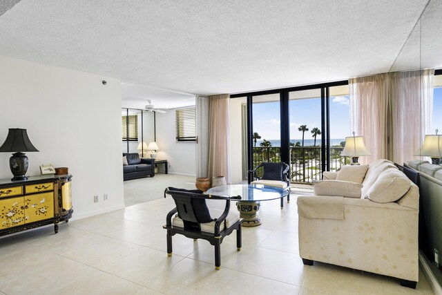 200 Ocean Trail Way Unit 106, Jupiter, FL 33477 - living area featuring a textured ceiling, baseboards, light tile patterned floors, and a ceiling fan