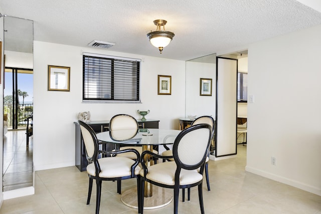 200 Ocean Trail Way Unit 106, Jupiter, FL 33477 - dining area with a textured ceiling, light tile patterned flooring, and baseboards
