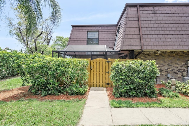 7678 Courtyard Run W, Boca Raton, FL 33433 - entrance to property with a gate, mansard roof, and brick siding