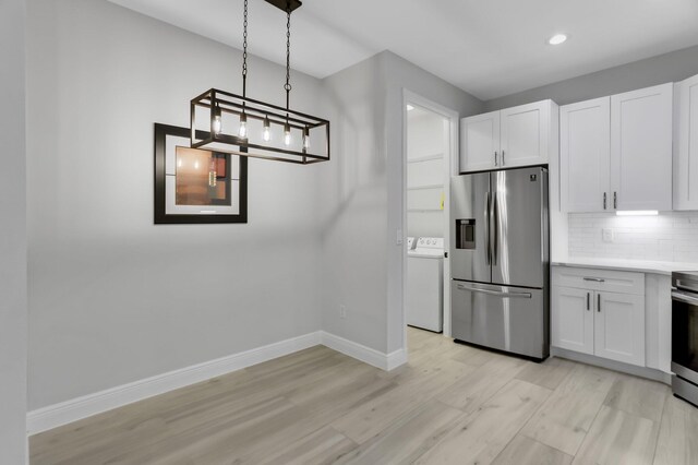 6365 Bella Cir Unit 705, Boynton Beach, FL 33437 - kitchen featuring stainless steel appliances, washer / clothes dryer, light wood-style floors, baseboards, and tasteful backsplash
