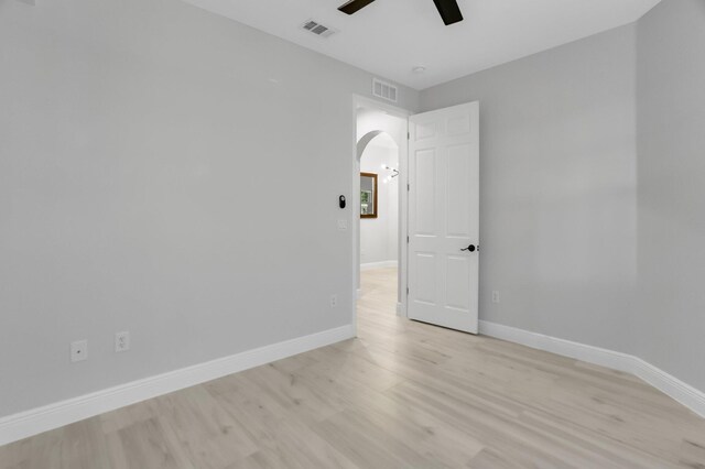 6365 Bella Cir Unit 705, Boynton Beach, FL 33437 - unfurnished room featuring ceiling fan, arched walkways, light wood-style flooring, and baseboards