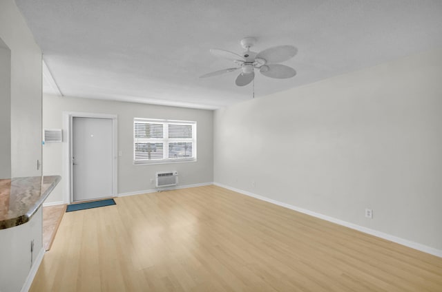 2430 S Federal Hwy Unit 10, Boynton Beach, FL 33435 - unfurnished living room featuring a ceiling fan, an AC wall unit, light wood-type flooring, and baseboards