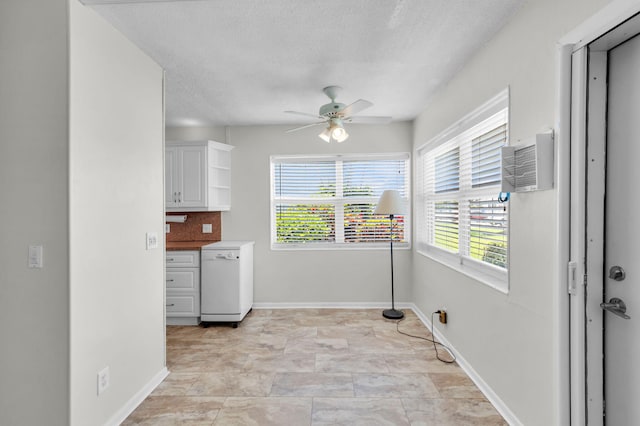 2430 S Federal Hwy Unit 10, Boynton Beach, FL 33435 - laundry area with a ceiling fan, a wall unit AC, a textured ceiling, and baseboards