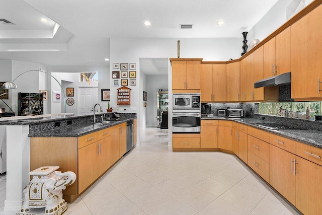 7208 Corning Cir, Boynton Beach, FL 33437 - kitchen with stainless steel appliances, under cabinet range hood, backsplash, a sink, and dark stone countertops