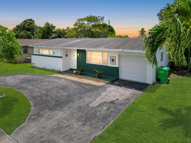 8650 NW 29th St, Sunrise, FL 33322 - single story home with asphalt driveway, a garage, a lawn, central air condition unit, and stucco siding