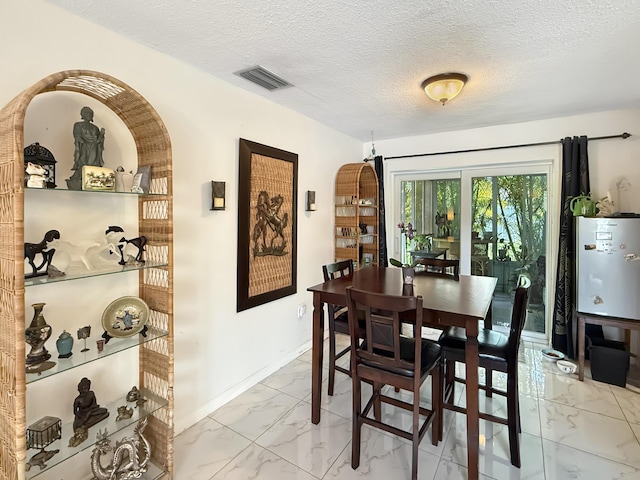 8650 NW 29th St, Sunrise, FL 33322 - dining space featuring light marble finish floors, a textured ceiling, and baseboards