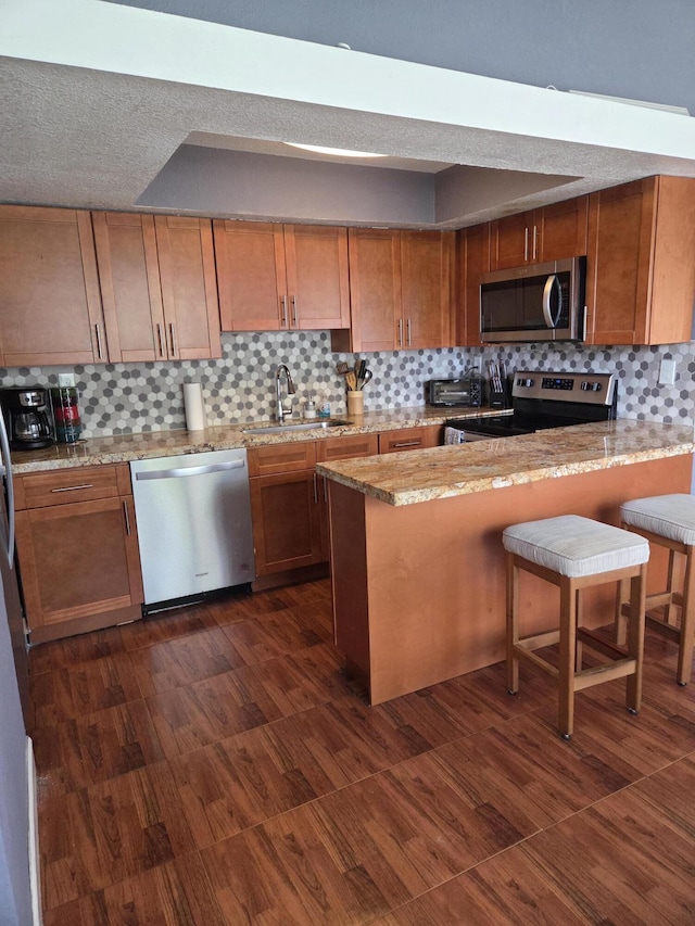 152 NW 14th Ave, Boynton Beach, FL 33435 - kitchen featuring appliances with stainless steel finishes, a sink, tasteful backsplash, and brown cabinetry